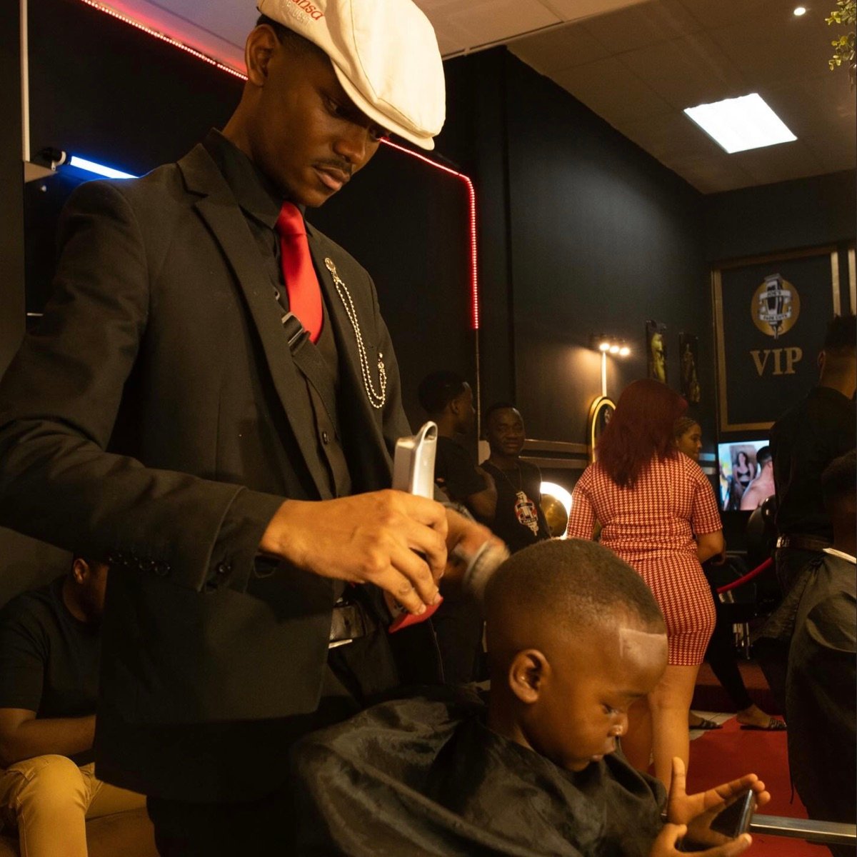 Joe's Fade Cuts barber in signature suit and red tie at work
